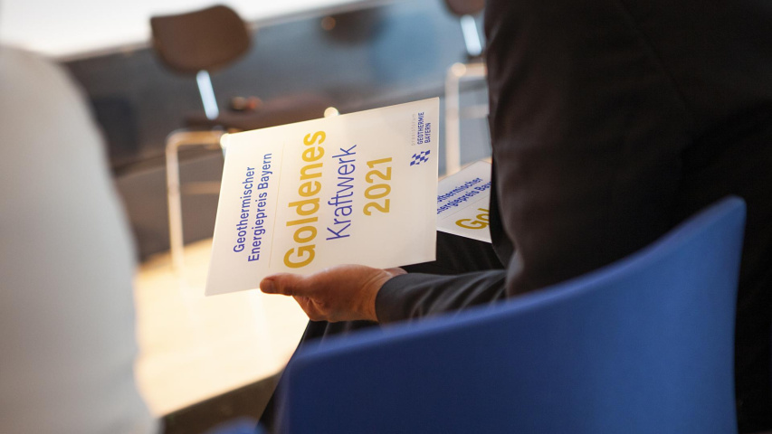 Mann hält Dokument in der Hand zum Goldenen Kraftwerk 2021
